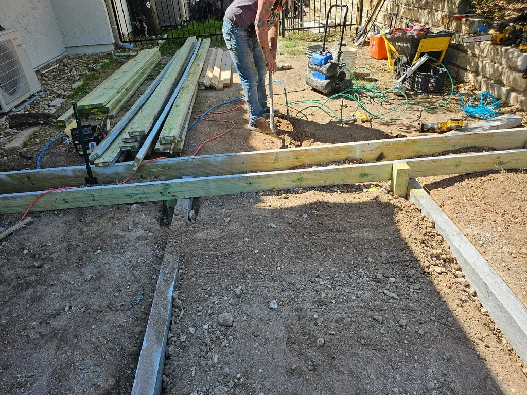 Deck frame being leveled on footings