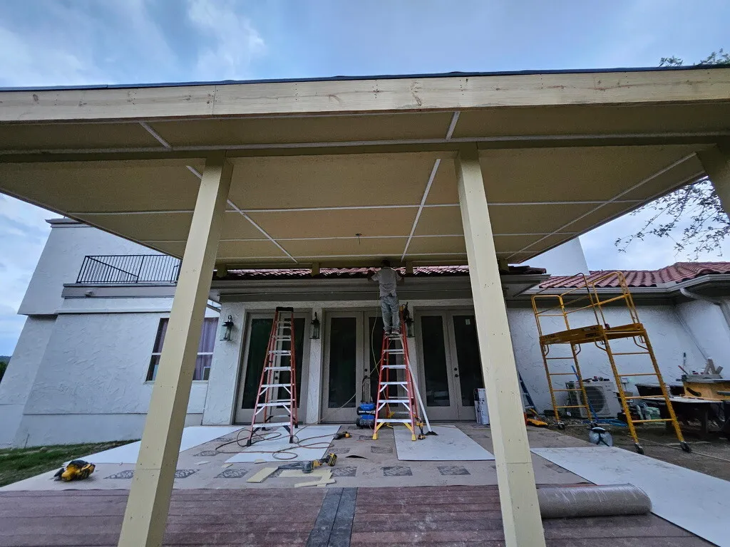 Underside of the patio cover being painted, ladders and scaffold in place