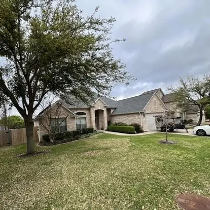 Stone and brick single-story home with a freshly painted trim and garage